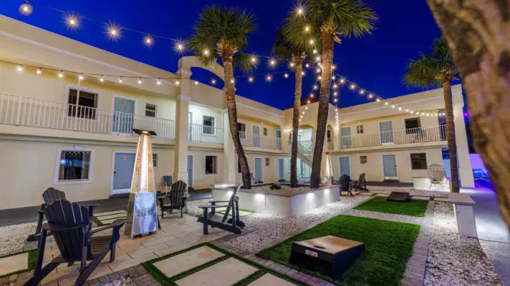 Annex building courtyard in the evening, string lights and palm trees
