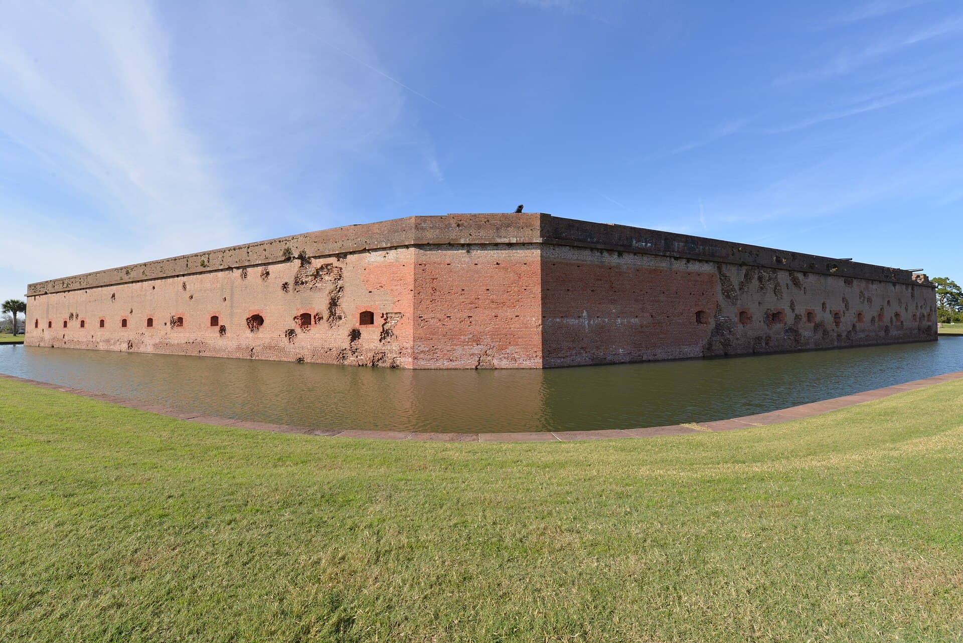 Fort Pulaski's brick ramparts and surrounding moat under a blue sky